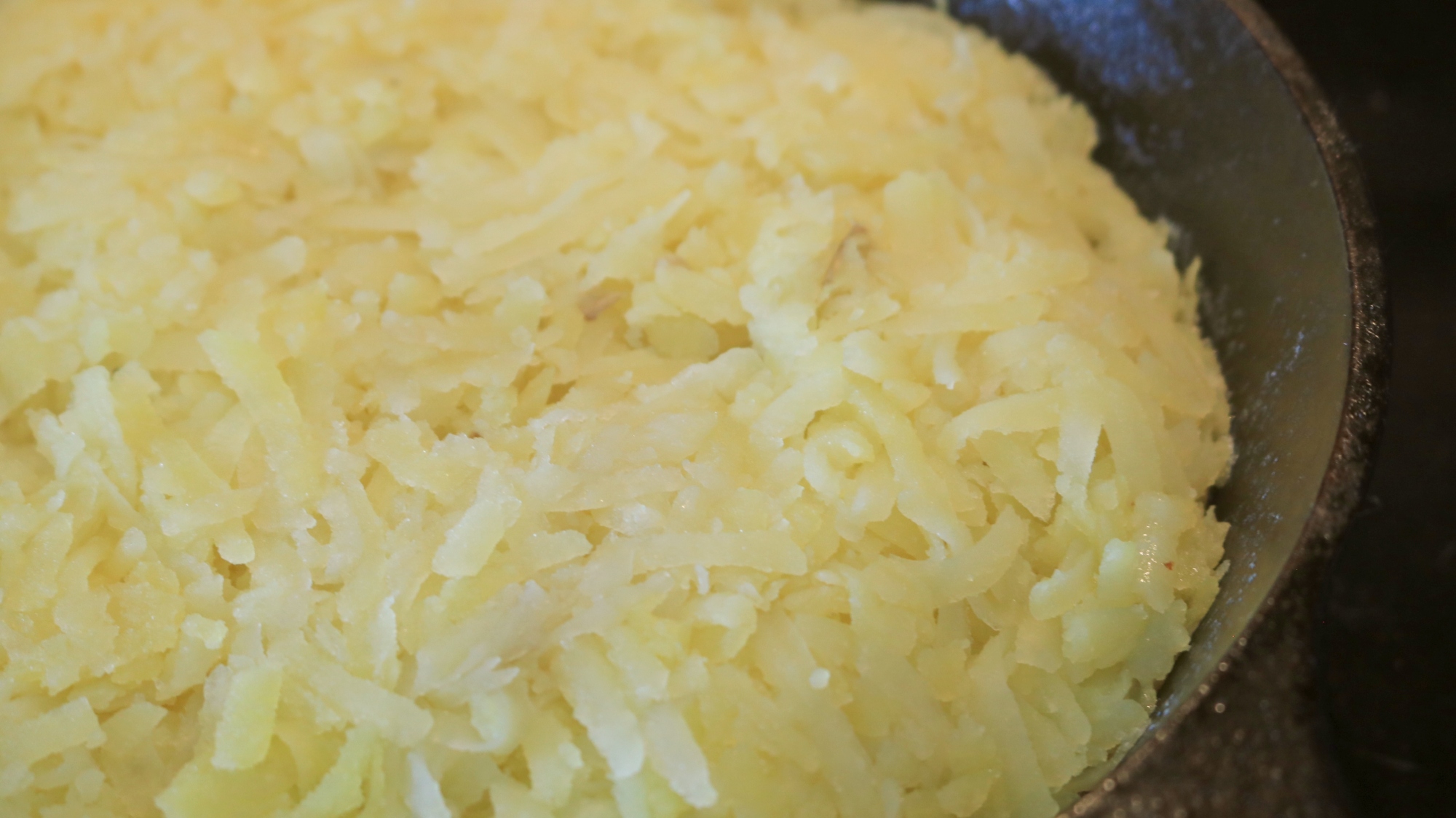 Potato shreds in a frying skillet.